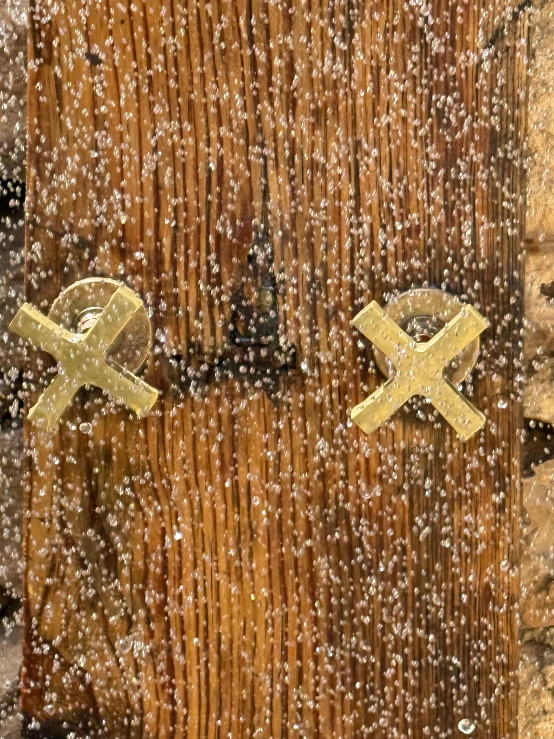 The outdoor shower's brass handles on weathered wood