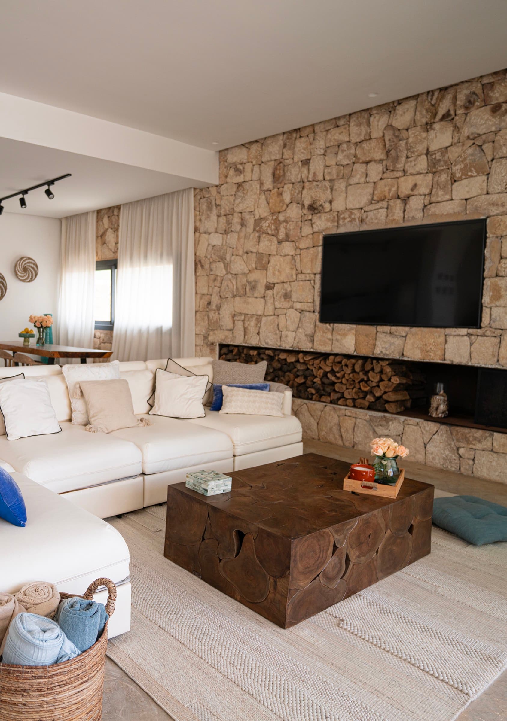The lounge's stone wall — fireplace, firewood and television